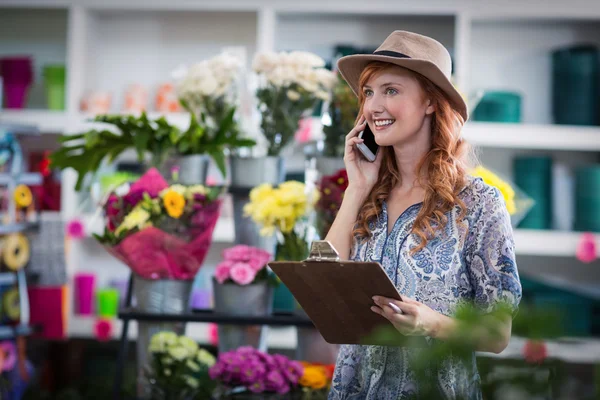 Blumenhändler nimmt Bestellung per Handy entgegen — Stockfoto