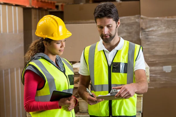 Lavoratori di magazzino discutono con appunti — Foto Stock