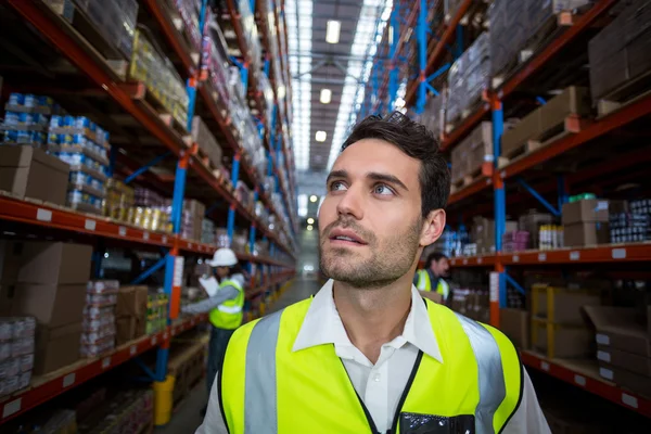 Warehouse worker looking at packages — Stock Photo, Image