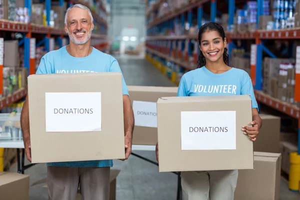 Two volunteers holding donations boxes — ストック写真