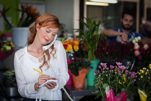 Floristería tomando una orden por teléfono —  Fotos de Stock