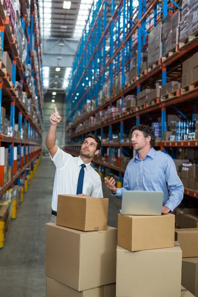 Warehouse workers discussing with laptop — Stock Photo, Image