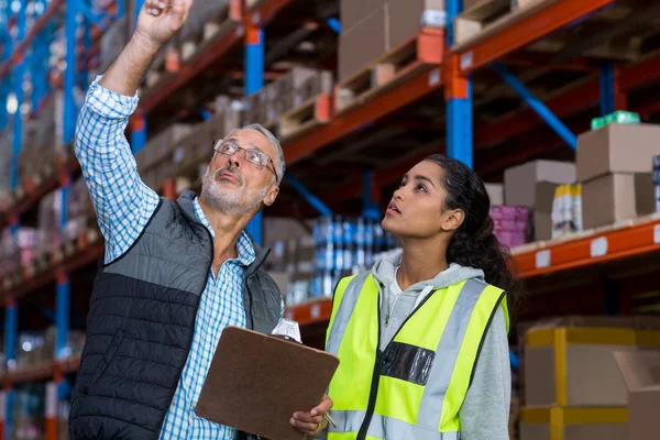 Warehouse workers discussing with clipboard — Stock Photo, Image