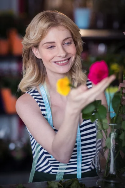 Vrouwelijke bloemist schikken van bloemen in vaas — Stockfoto