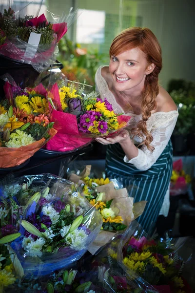 Female florist touching flower bouquet — Stock Photo, Image