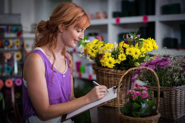 Florista escrevendo na área de transferência — Fotografia de Stock