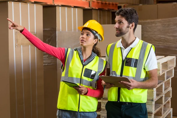 Warehouse workers discussing with clipboard — Stock Photo, Image