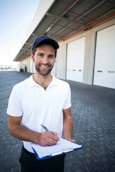 Delivery man holding clipboard — Stock Photo, Image
