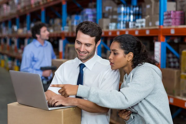 Warehouse workers working on laptop — Stock Photo, Image