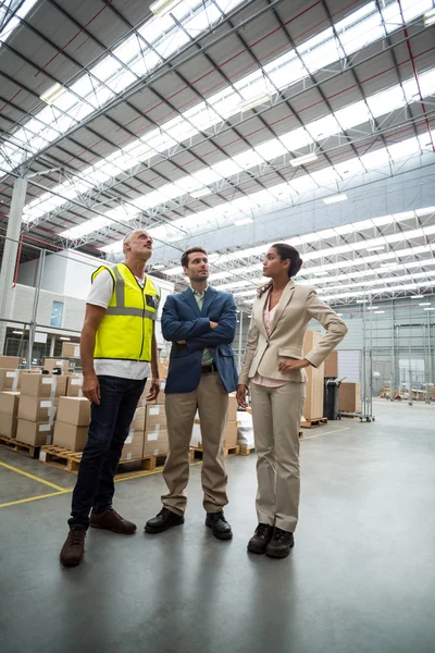Warehouse managers discussing with worker — Stock Photo, Image