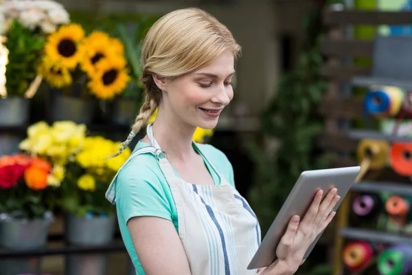 Флорист використовує планшет у квітковому магазині — стокове фото