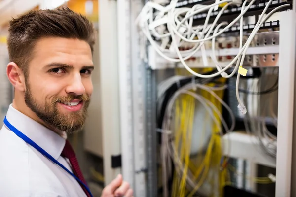 Technicien souriant debout dans une salle de serveurs — Photo