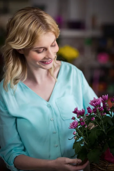 Florist arranging flowers in basket — Stock Photo, Image