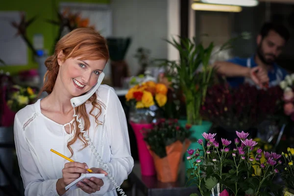 Florist taking an order on telephone — Stock Photo, Image