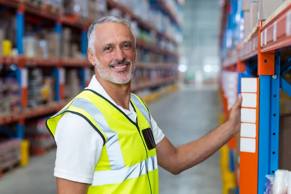 Magazzino lavoratore in piedi vicino scaffale — Foto Stock