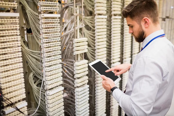 Technician using tablet while analyzing server — Φωτογραφία Αρχείου