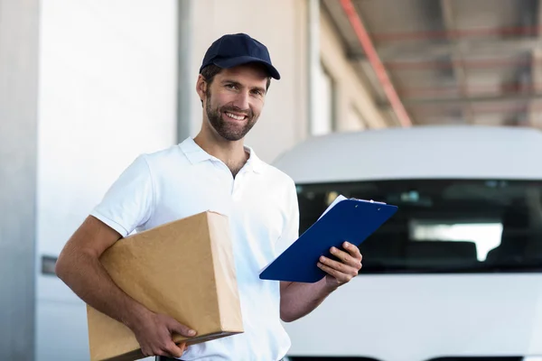 Zusteller hält Paket und Klemmbrett — Stockfoto