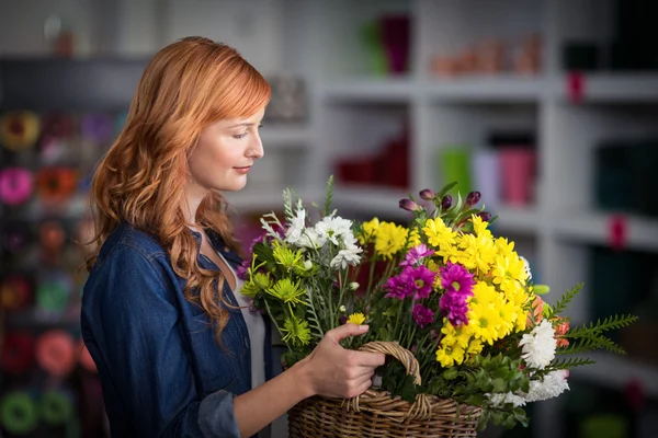 Blumenhändler hält Korb mit Blumen — Stockfoto