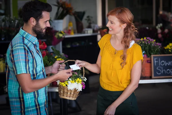 Florist giving visiting card and flower basket — ストック写真