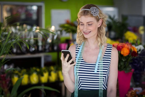 Floristería femenina sosteniendo teléfono móvil —  Fotos de Stock