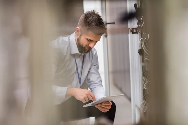 Technician using tablet while analyzing server — Stock Photo, Image