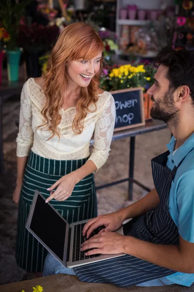 Casal usando laptop na loja de flores — Fotografia de Stock