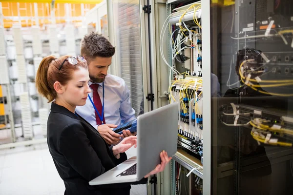 Technicians using laptop while analyzing server — Stock Photo, Image