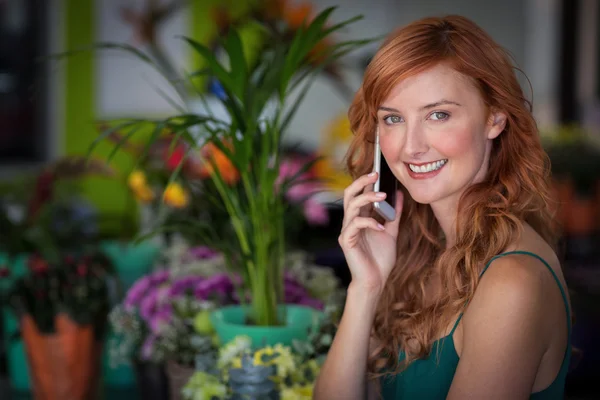 Floristería hablando por teléfono móvil en la tienda —  Fotos de Stock