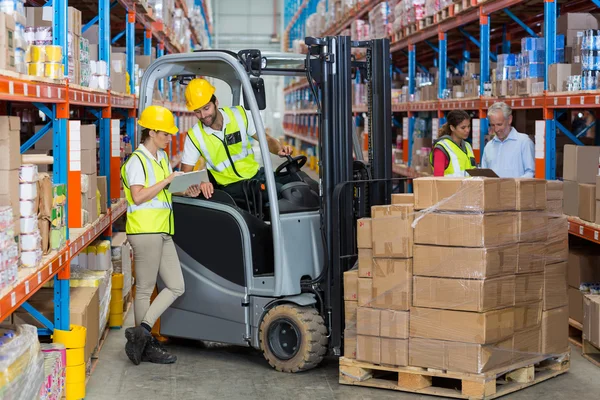 Trabajador y trabajadora discutiendo sobre portapapeles — Foto de Stock