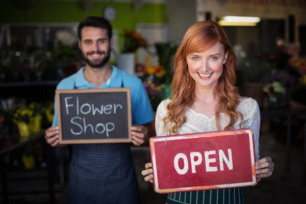 Vrouw en man houden open uithangborden — Stockfoto