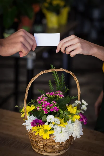 Florist giving visiting card to customer — Stock Photo, Image