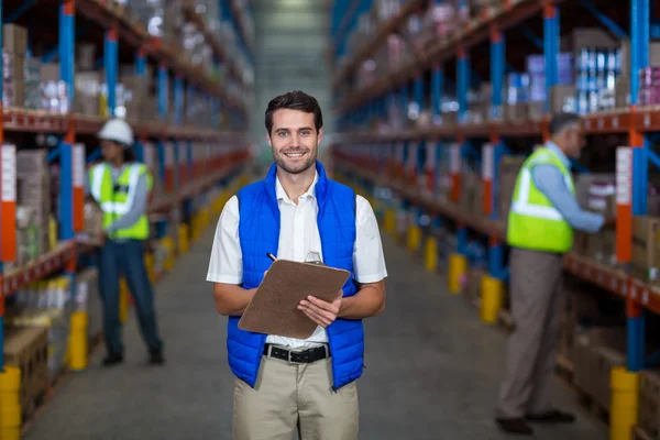 Warehouse worker holding clipboard — Stock Photo, Image