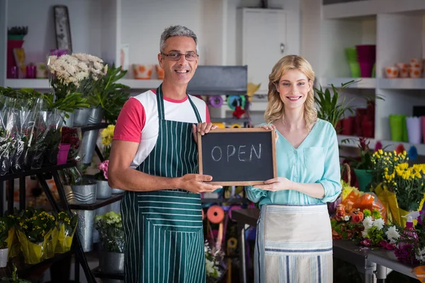 florists holding open sign on slate