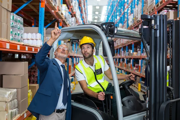 Gerente de almacén interactuando con trabajador masculino — Foto de Stock