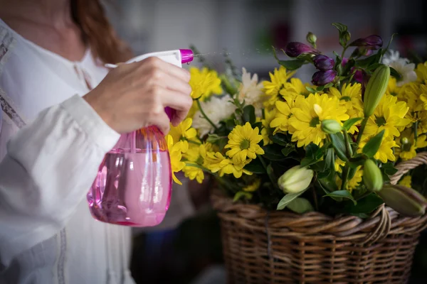 Blumenhändler sprüht Wasser auf Blumen — Stockfoto