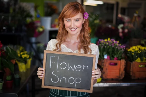 Floristen halten Schiefer mit Blumenladen-Schild — Stockfoto