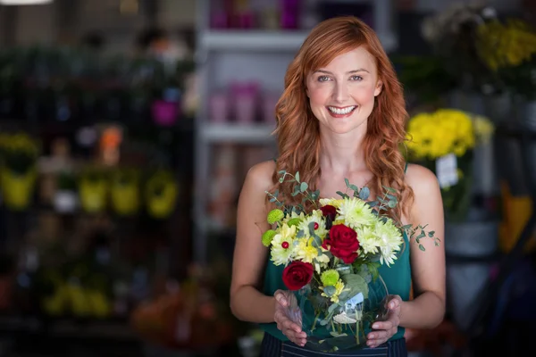 Florista segurando vaso de flores na loja — Fotografia de Stock