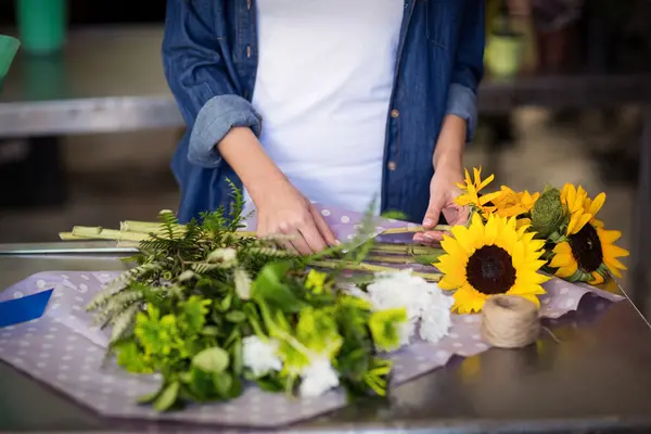 Fiorista avvolgendo mazzo di fiori — Foto Stock