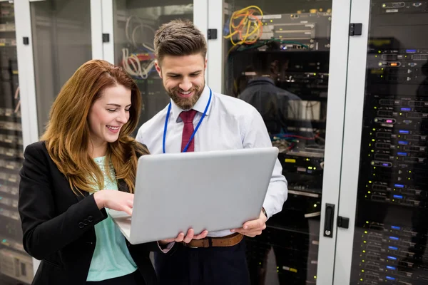 Technici, die laptop gebruiken bij het analyseren van de server — Stockfoto