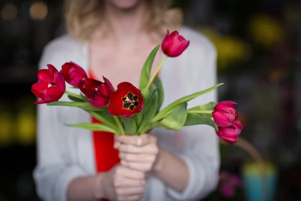 Blumenhändler hält Blumenstrauß im Geschäft — Stockfoto