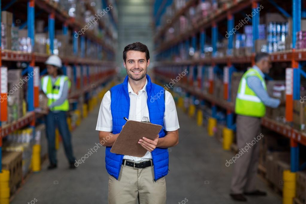 Warehouse worker holding clipboard — Stock Photo ...