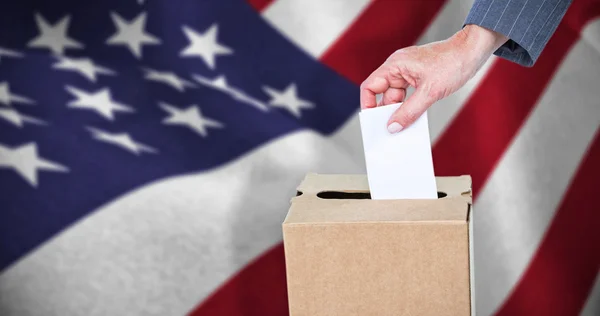 Businesswoman putting ballot in vote box — Stock Photo, Image