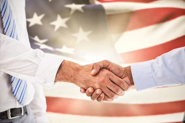 Apretón de manos contra ondulación de bandera americana — Foto de Stock