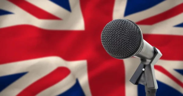 Микрофон против национального флага — стоковое фото