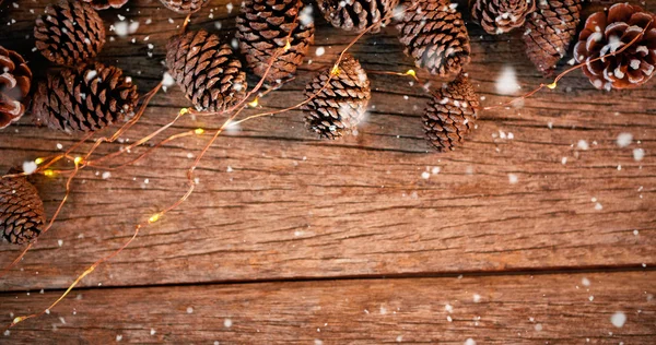 Сосновый конус с огнями на деревянной доске — стоковое фото