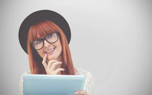 Imagen compuesta de una mujer hipster sonriente usando su tableta —  Fotos de Stock