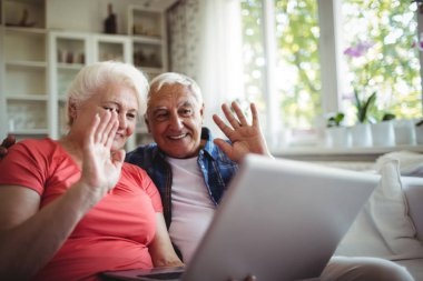 Senior couple video chatting on laptop clipart