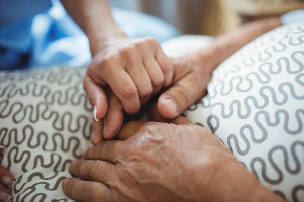 Медсестра, держащаяся за руки пожилой женщины — стоковое фото