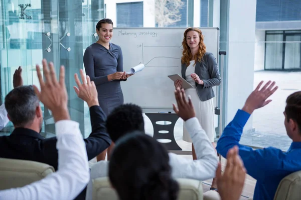 Collega's verhogen handen tijdens vergadering — Stockfoto