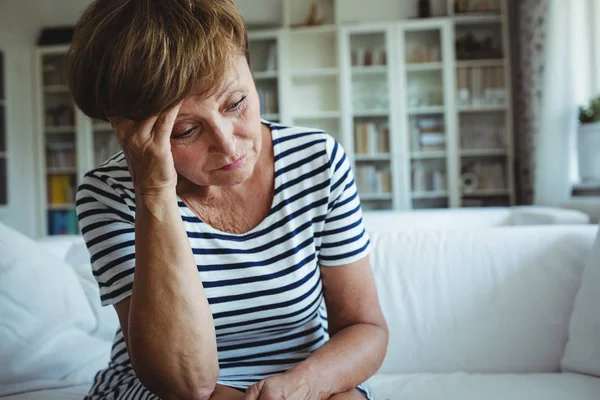 Spänd kvinna sittande på soffan i vardagsrummet — Stockfoto